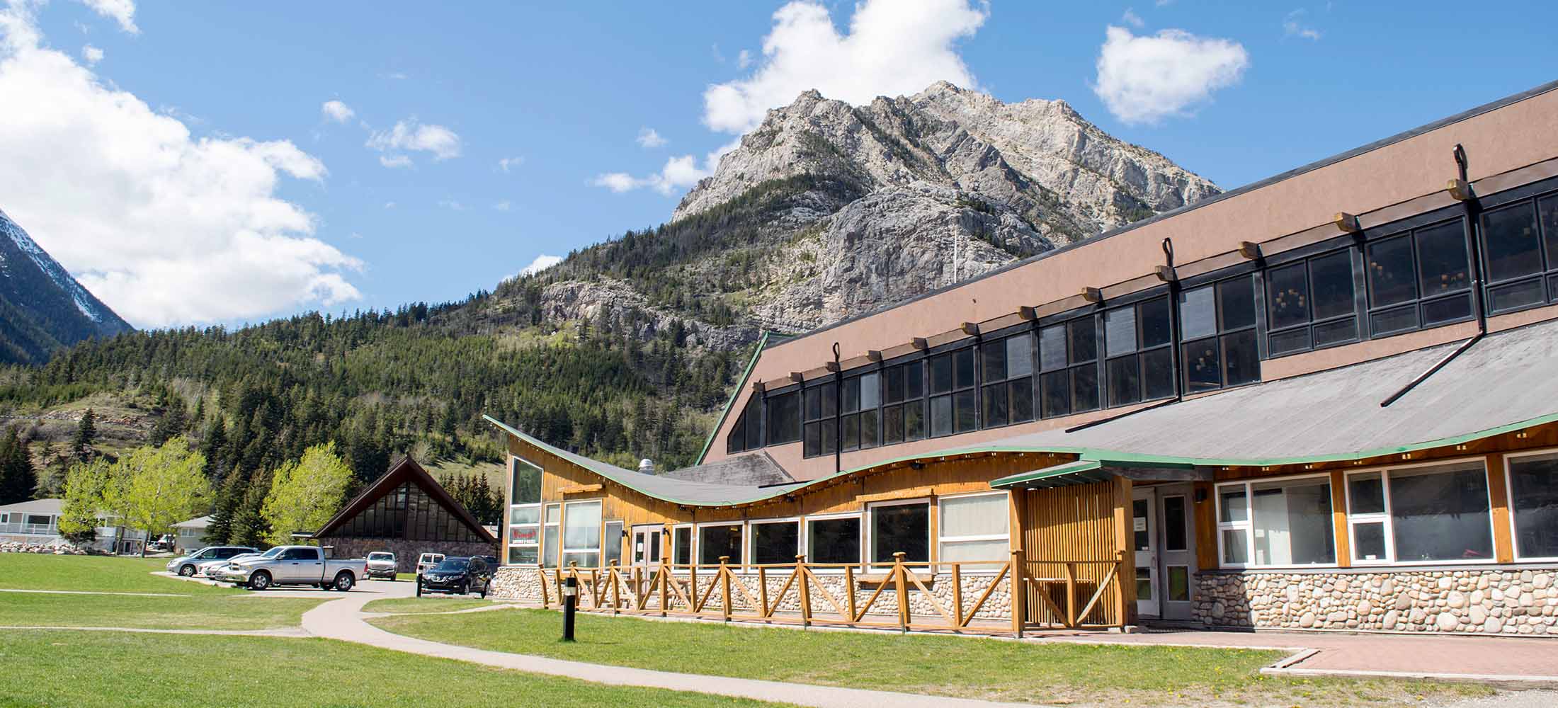 AN exterior photo of the Waterton Lakes Lodge & Vimy's Lounge and Grill with Bears Hump in the background.